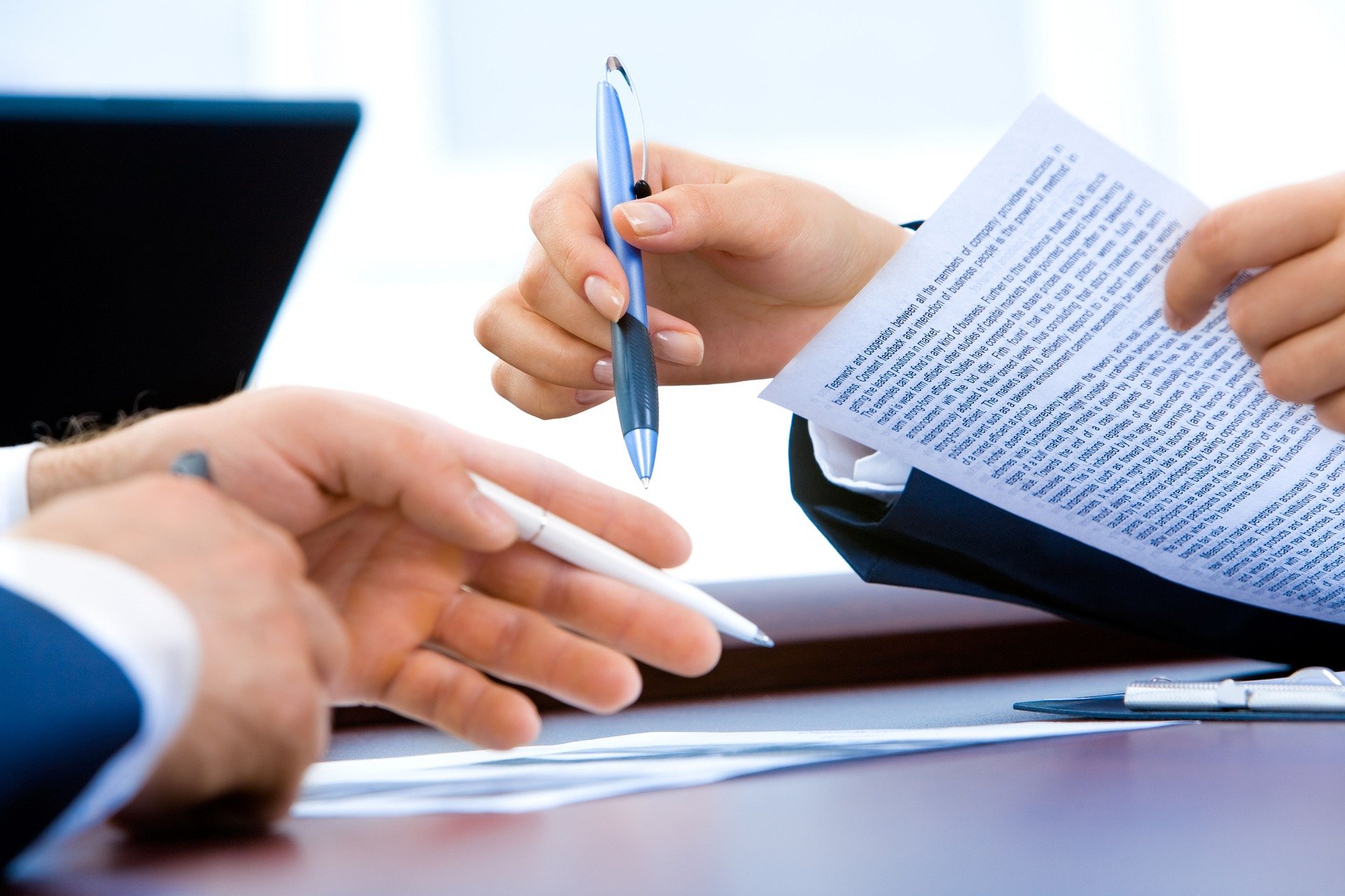 Hands of two people reviewing a contract - Select Contract Disputes and Drafting Under Ohio Law Contract Disputes and Drafting Under Ohio Law - Joseph & Joseph & Hanna